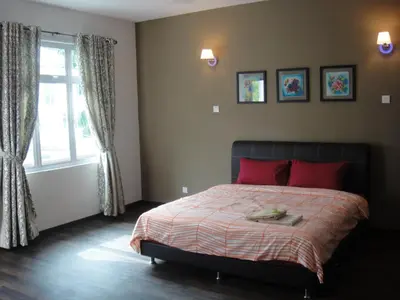 a bedroom with a bed with red pillows and a window at Batu Ferringhi - Shamrock Beach Villas, Penang in Batu Ferringhi