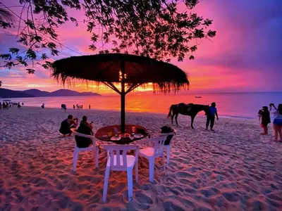 a table and chairs on the beach with a horse in the background at (New) Beachside Antique Villa@14 pax in George Town