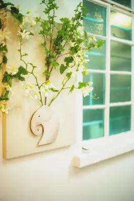 a vase with a plant on a window sill at FA House by the Beach in Tanjung Bungah