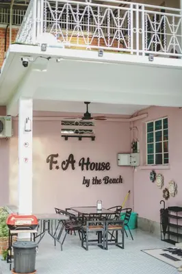 a pink wall with a sign that reads fa house by the beach at FA House by the Beach in Tanjung Bungah