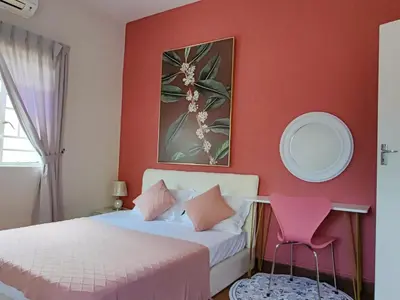 a bedroom with two beds and a pink wall at FA House by the Beach in Tanjung Bungah