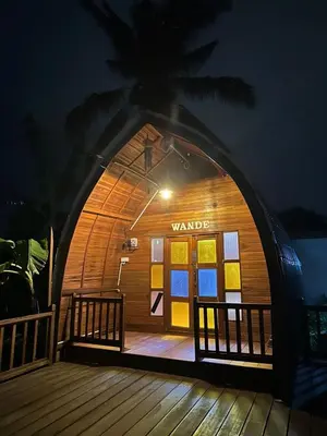 a warden building with a wooden deck at night at LBA chalet in Balik Pulau