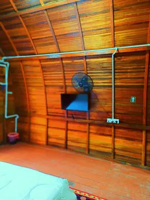 a room with a wooden wall with a clock on it at LBA chalet in Balik Pulau
