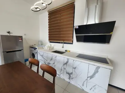 a kitchen with a counter with a sink and a refrigerator at Executive Premium Urban Suites - Jelutong in Jelutong