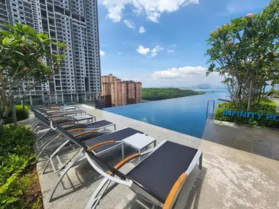 a row of chaise lounge chairs overlooking a river at Executive Premium Urban Suites - Jelutong in Jelutong