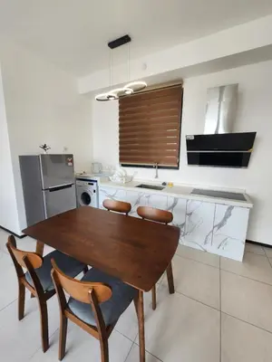 a kitchen with a wooden table and chairs at Executive Premium Urban Suites - Jelutong in Jelutong