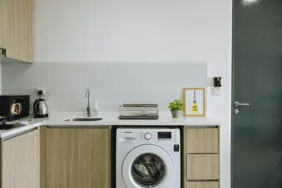 a kitchen with a washing machine under a counter at The ELM, 2BR Cityview by W. Stay @ Tropicana 218 Macalister in George Town