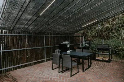 a patio with a table and chairs and a fence at Safari Tent with Private Jacuzzi in Brinchang