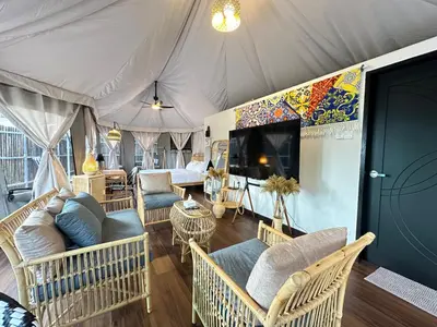 a living room with couches and a tv in a tent at Safari Tent with Private Jacuzzi in Brinchang