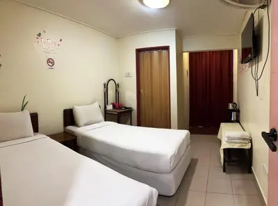 a hotel room with two beds and a television at Hotel BB Inn @ Cameron in Cameron Highlands
