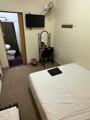 a bedroom with a bed and a desk and a television at Hotel BB Inn @ Cameron in Cameron Highlands