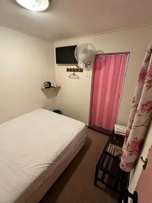 a bedroom with a bed and a pink door at Hotel BB Inn @ Cameron in Cameron Highlands