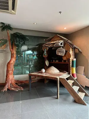 a room with a table and a tree in it at Laguna Raudhah Apartment in Lumut
