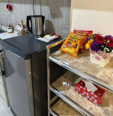 a kitchen with a counter and a shelf with gifts at Laguna Raudhah Apartment in Lumut