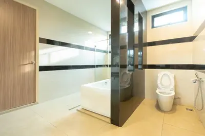 a bathroom with a toilet and a tub and a sink at Muji Style 5BR Ferringhi Beach House 15Pax in Batu Ferringhi