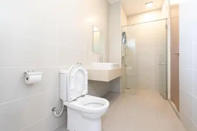 a white bathroom with a toilet and a sink at Muji Style 5BR Ferringhi Beach House 15Pax in Batu Ferringhi