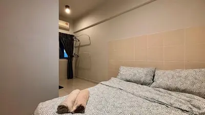 a bedroom with a bed and a bathroom with a window at Spacious HOUSE 4R 8pax WiFi-S Pic-Airport in Bayan Lepas