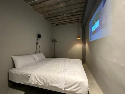 a bedroom with a white bed and a tv at Georgetown landed Guest House WL in George Town