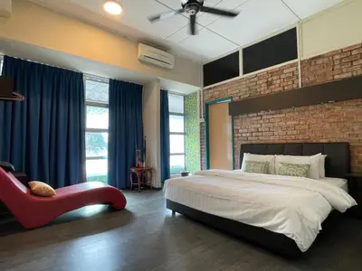 a bedroom with a large bed and a brick wall at GOPENG INN Homestay in Gopeng