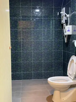 a bathroom with a toilet and a blue tiled wall at GOPENG INN Homestay in Gopeng