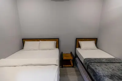 two beds in a small room with white sheets at 5R4B 15Pax V KTV,KID'S POOL,POOL TABLE NEAR USM,LWE HOSPITAL,SPI ARENA in George Town
