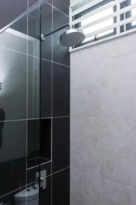 a bathroom with a glass shower with a toilet at Varnen Cozy Haven - EVCharger in Bukit Mertajam