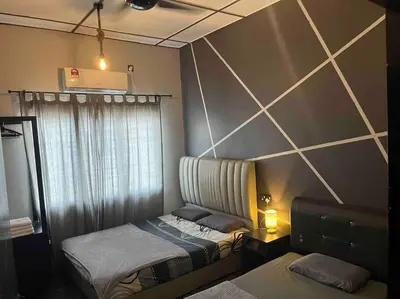 a bedroom with two twin beds and a wall with at Wi-Fi 100MB Free Ipoh Holiday Suite Taman Anda A5 in Ipoh