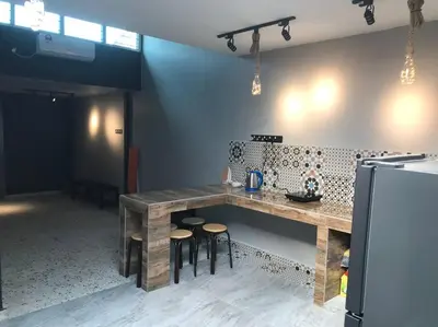 a kitchen with a wooden table and stools at Wi-Fi 100MB Free Ipoh Holiday Suite Taman Anda A5 in Ipoh