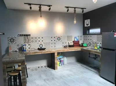 a kitchen with a counter and a refrigerator at Wi-Fi 100MB Free Ipoh Holiday Suite Taman Anda A5 in Ipoh