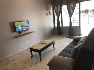 a living room with a couch and a coffee table at Wi-Fi 100MB Free Ipoh Holiday Suite Taman Anda A5 in Ipoh