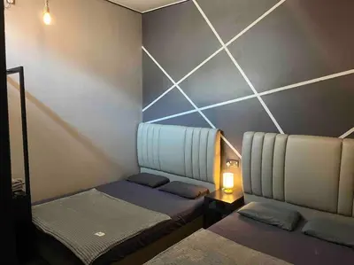 a small room with two beds and a lamp at Wi-Fi 100MB Free Ipoh Holiday Suite Taman Anda A5 in Ipoh