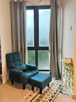 a living room with a chair and a large window at Lily Fair ~ Cameron Highlands in Tanah Rata