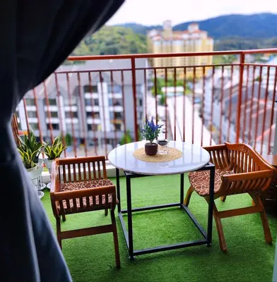 a table and two chairs on a balcony at D'Elegant Suite - Emerald Avenue in Cameron Highlands