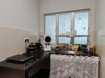 a kitchen with a counter with a stove and a window at D'Elegant Suite - Emerald Avenue in Cameron Highlands