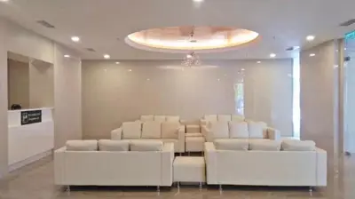 a waiting room with white leather chairs and a chandelier at Champs Elysees by Landmark @ Kampar in Kampong Malim Nawar