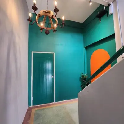 a room with a green wall and a chandelier at Ipoh town centre - safari 5 pax(2BR) in Ipoh
