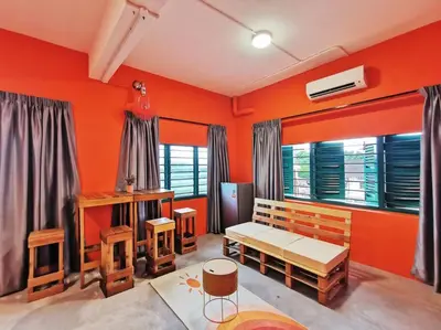 a living room with orange walls and wooden furniture at Ipoh town centre - safari 5 pax(2BR) in Ipoh