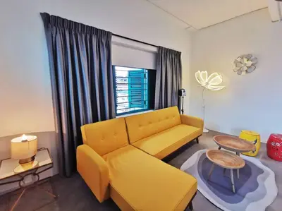 a living room with a yellow couch and a table at Ipoh town centre eastern oriental 8 pax(2BR) in Ipoh