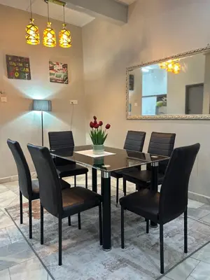 a dining room with a table and chairs and a mirror at Hz Homestay Bertam in Kepala Batas