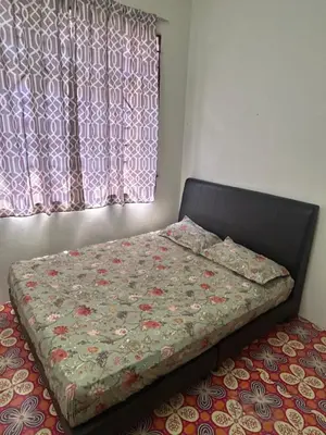 a bed with a quilt on it next to a window at Hz Homestay Bertam in Kepala Batas