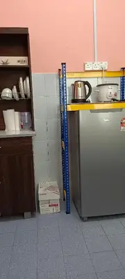 a kitchen with a counter and a shelf with a tea kettle at Inap Mudah in Seri Iskandar