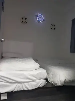 a bedroom with two beds and a wall with a clock at BLUE DOME (Santorini) @ Night Market, Cameron Highlands in Brinchang