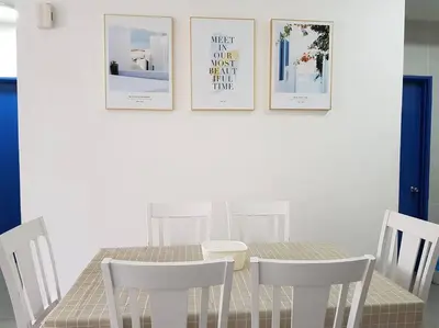 a dining room table with chairs and pictures on the wall at BLUE DOME (Santorini) @ Night Market, Cameron Highlands in Brinchang