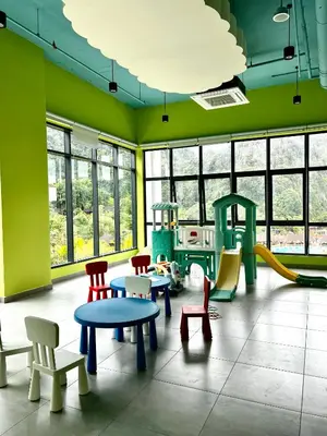 a room with colorful chairs and tables and a playground at Ipoh Onsen family suite l Lost World view in Tambun