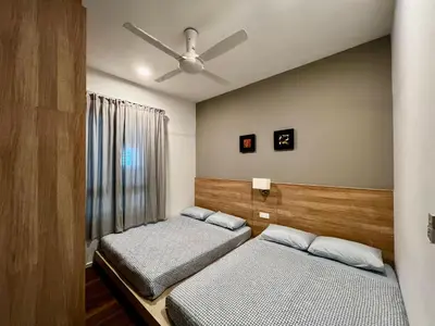a bedroom with two beds and a ceiling fan at Ipoh Onsen family suite l Lost World view in Tambun