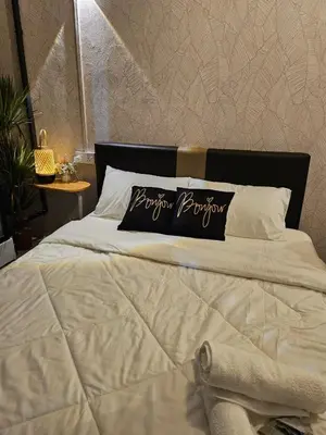 a bed with a black and white pillow on it at Le Melur in George Town
