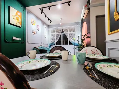 a dining room with a table with plates and chairs at Moon Classic Falim by Irainbow in Ipoh