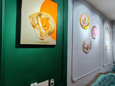 a room with a green wall with pictures on it at Moon Classic Falim by Irainbow in Ipoh