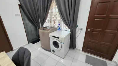 a laundry room with a washing machine and a window at Villa Fatima in Sitiawan