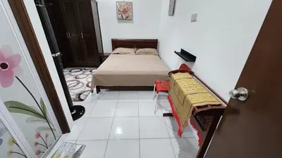 a small bedroom with a bed and a tiled floor at Villa Fatima in Sitiawan